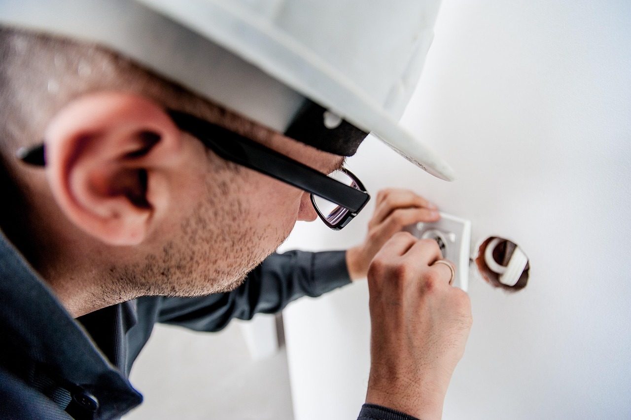Professional electrician inspecting a switch socket